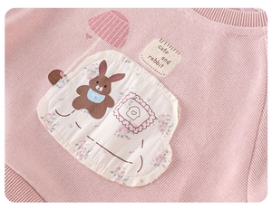 Close-up detail of cartoon rabbit embroidery and floral print on pink girls' sweatshirt