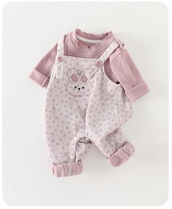 Close-up of pink baby bodysuit set with floral pattern and cute rabbit embroidery