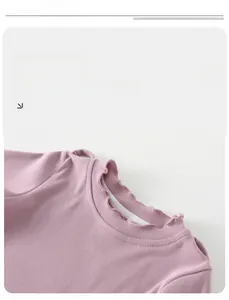 Close-up of pink baby top with ruffled collar and cutout shoulder detail in soft knit