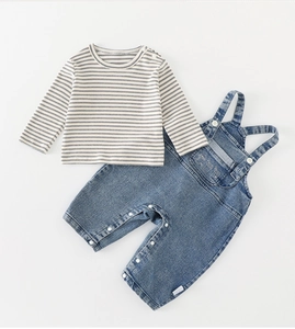 Détail de la salopette en jean pour bébé avec t-shirt rayé, broderie et boutons pressions