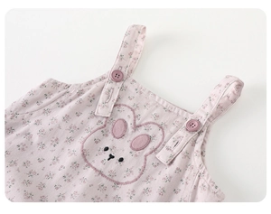 Close-up of baby romper with floral print, rabbit embroidery and button straps