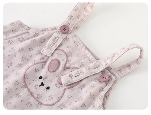 Detail of floral baby romper with cute rabbit embroidery and adjustable purple buttons