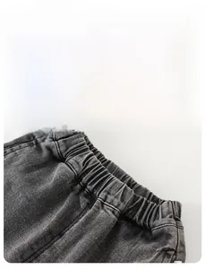 Detailed macro view of the high-elasticity ribbed waistband on boys denim joggers