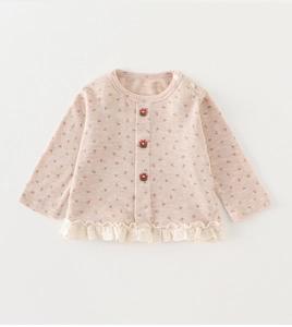 Détail du cardigan à fleurs pour bébé avec ourlet en dentelle et boutons fleuris