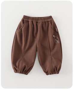 Detail of kids brown cotton sweatpants featuring elastic waist and house print