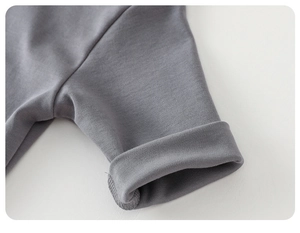 Close-up of soft grey knitted cotton fabric and rolled cuff detail on toddler shirt
