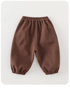 Detail of dark brown kids jogger pants with elastic waistband and ribbed ankle cuffs