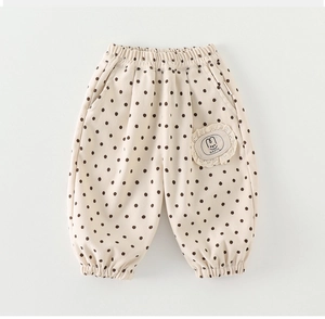 Detail of baby polka dot joggers with elastic cuffs and happy rabbit embroidered patch
