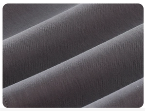 Detailed close-up of dark grey knitted cotton fabric texture with soft wavy folds