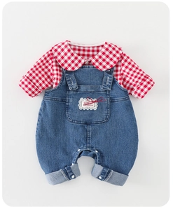 Détail de l'ensemble salopette en jean pour bébé avec chemise à carreaux et patch de Noël