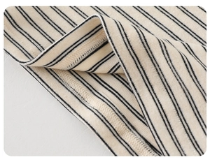 Détail de la couture surjet haute densité sur un tissu en maille rayée souple