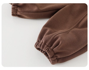 Close-up of elastic ribbed cuff on dark brown cotton sweatpants for toddlers