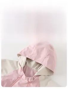 Detail view of pink and beige kids waterproof jacket with protective zipper and lining