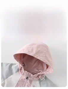Dettaglio della giacca a vento da bambina con design color-block e cappuccio regolabile