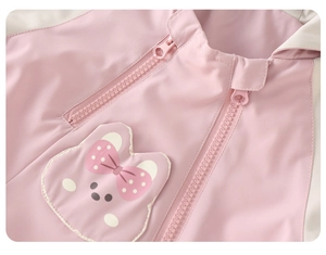 Detail of pink toddler windbreaker with dual zippers and cartoon bear embroidery