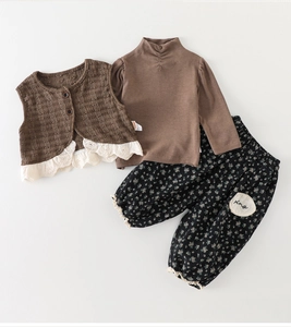 Detailed flat lay of a girls three-piece fall set including lace vest and floral pants