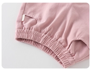 Makro-Detail der rosa Babyhose aus Strickbaumwolle mit Gummibund und kleiner Tasche