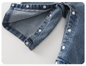 Détail des boutons-pression blancs et des coutures sur l'entrejambe du denim bébé