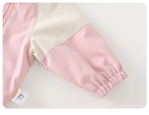 Detail of pink and beige windbreaker elastic cuffs with size 73 label and contrast stitching