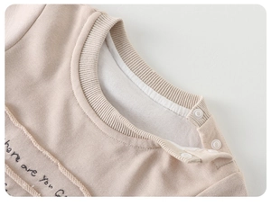 Detail von Baby-Strampler-Ausschnitt mit Rippbündchen und weißen Schulter-Druckknöpfen
