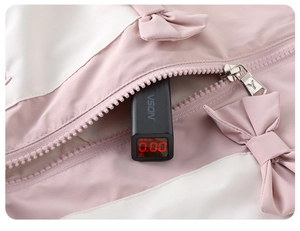 Dettaglio del fiocco rosa e zip su giacca da bambina con test di sicurezza fluorescenza
