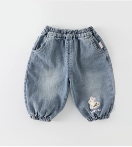 Détail d'un jogging en jean bleu clair avec broderie lapin et taille élastique enfant