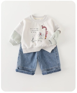 Detail of baby outfit featuring a mock-layered beige sweatshirt and blue denim shorts