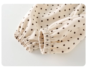 Detail of baby polka dot pants featuring elastic ribbed cuffs and soft cotton fabric