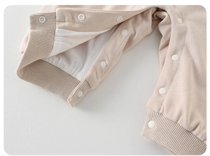 Detail eines Baby-Stramplers mit Druckknöpfen und Rippbündchen für einfaches Wickeln