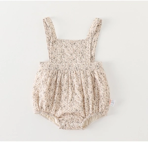 Nahaufnahme eines Baby-Stramplers mit Blumenmuster, Druckknöpfen und Rüschendetails