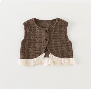 Close-up of brown knitted toddler vest featuring ripple texture and lace embroidery trim