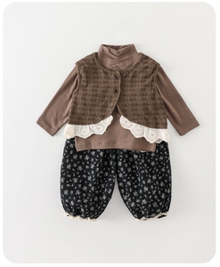 Close-up of girls' three-piece fall set with brown knit vest, lace trim, and floral pants