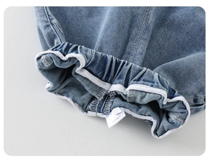 Detail shot of blue denim cuff with elastic edge and durable white fabric piping