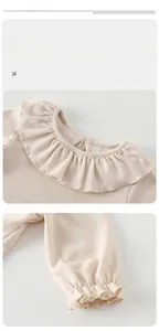 Detail von Rüschenkragen und elastischen Bündchen am beigen Baby-Strickset aus Baumwolle