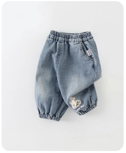 Détail d'un jean pour fille bleu clair avec broderie lapin et chevilles élastiquées