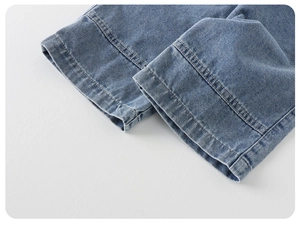 Detail of the double-stitched hem on children's washed blue denim jeans with durable seams