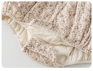 Detail eines geblümten Baby-Bodys mit Waffelstruktur und weißen Harz-Druckknöpfen