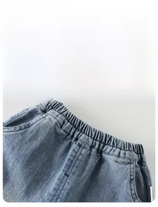 Détail de la taille élastique et des poches latérales de ce pantalon en jean bleu