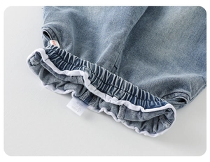 Gros plan d'un jean pour bébé avec ourlets élastiques et étiquette de lavage détaillée