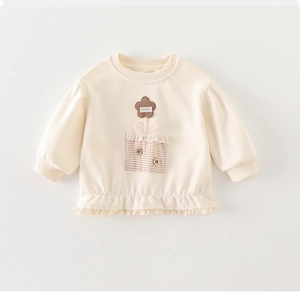 Détail du sweat pour bébé fille avec patch fleur 3D, ourlet en dentelle et poche à carreaux
