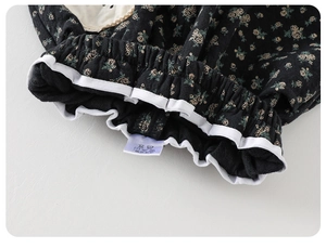 Detailed macro view of girls' floral pants elastic waistband with white piping and labels