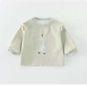 Close-up of light green baby sweatshirt featuring giraffe embroidery and ruffled shoulders
