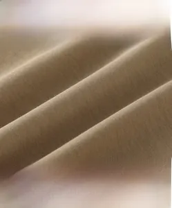 Detail of soft brown cotton fabric showing high-density weave and breathable texture