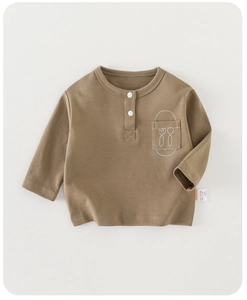 Detail of baby boy cotton henley shirt with cutlery print pocket and white buttons