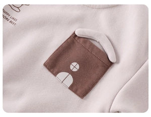 Detail of soft cotton knit top with puppy print and decorative brown chest pocket
