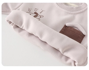 Close-up of pink toddler sweatshirt featuring cute cartoon dog print and brown pocket detail