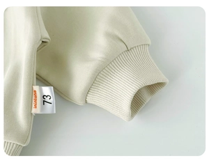 Detailansicht der cremefarbenen gerippten Baumwollbündchen für Säuglings-Sweatshirts