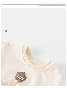 Détail du sweat-shirt en coton crème pour fille avec broderie florale et col rond côtelé