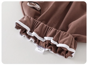 Macro view of brown kids trousers with elastic waist and cute rabbit patch detail