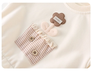 Détail du sweat pour bébé fille avec fleur en velours et poche en dentelle rose